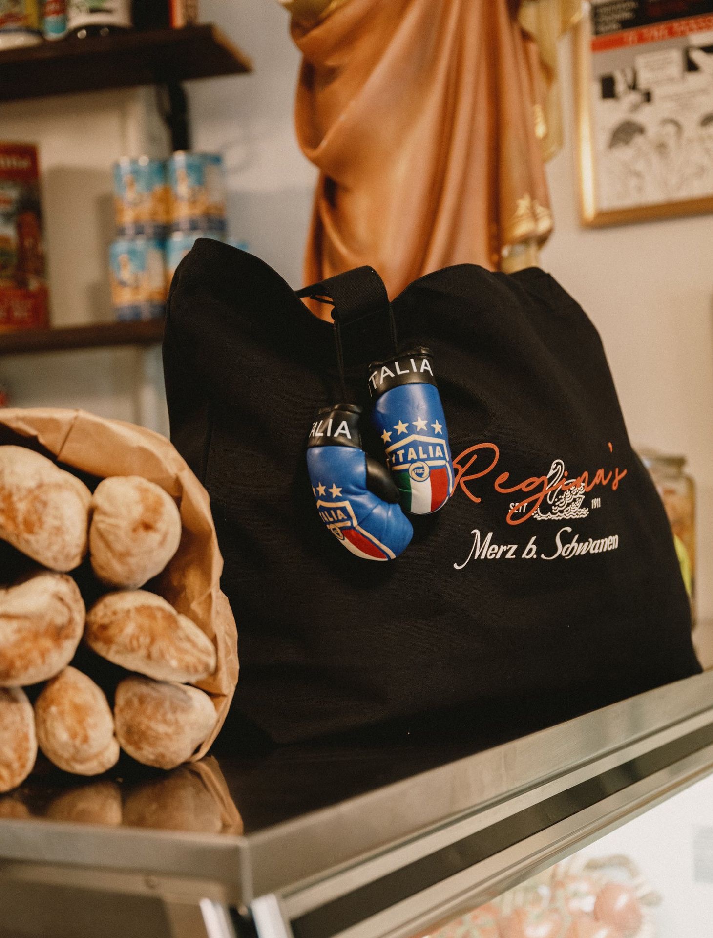 Black tote bag with logo branding next to groceries
