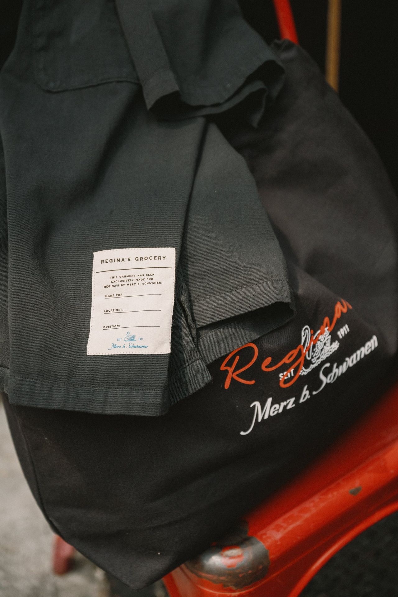 Closeup of a black worker shirt laying on a branded tote bag
