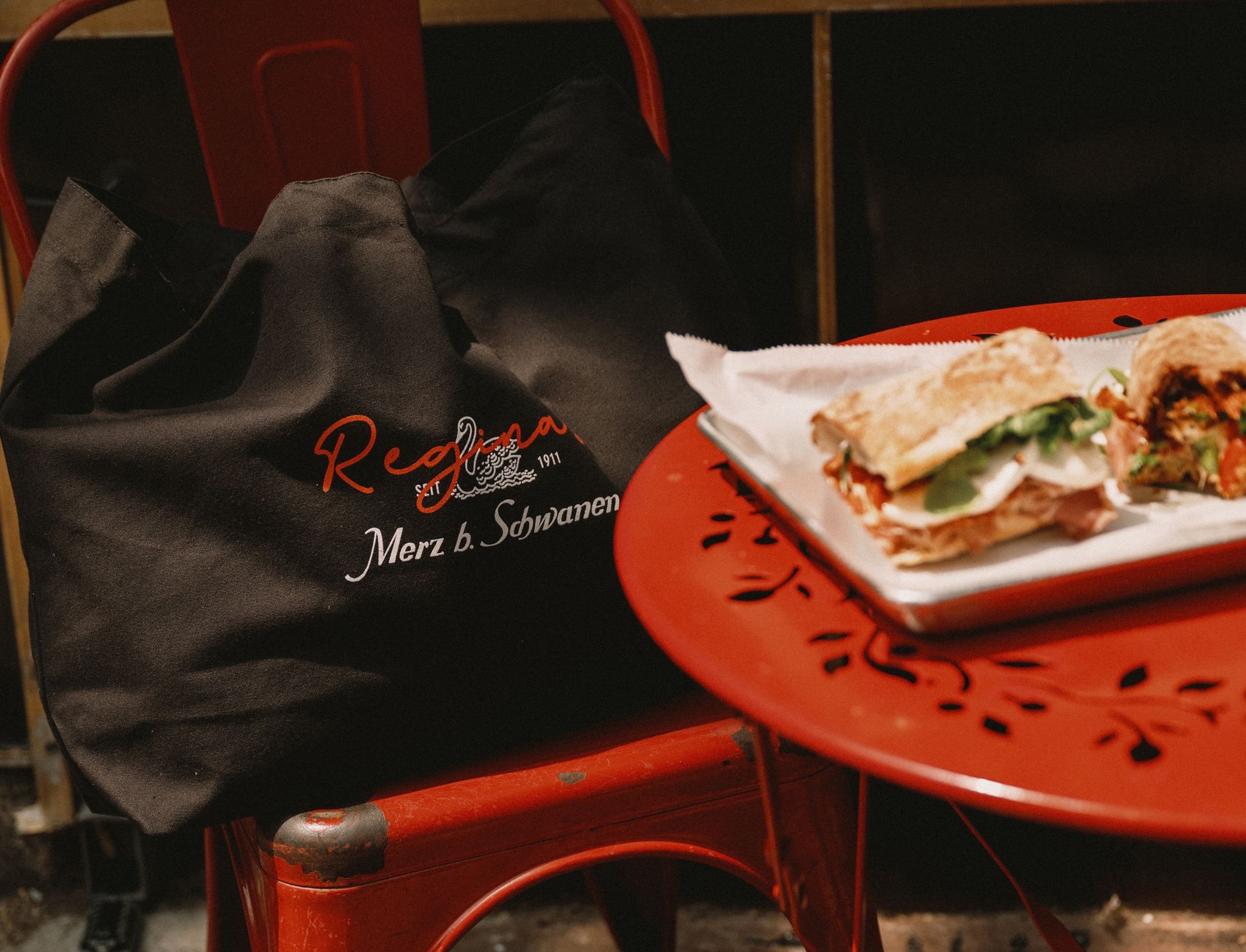 Closeup of a black tote bag next to a sandwich