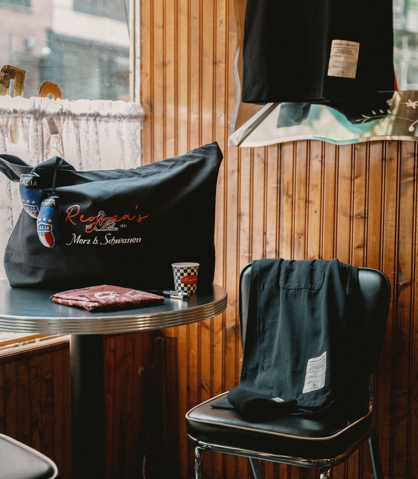 Black tote bag and bandana on a table next to black worker shirt