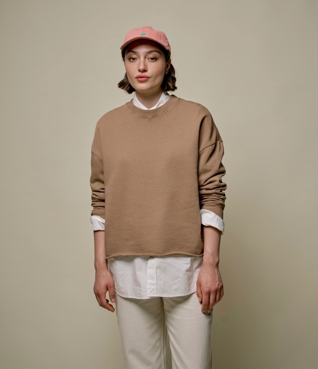 woman wearing brown sweatshirt and pink cap